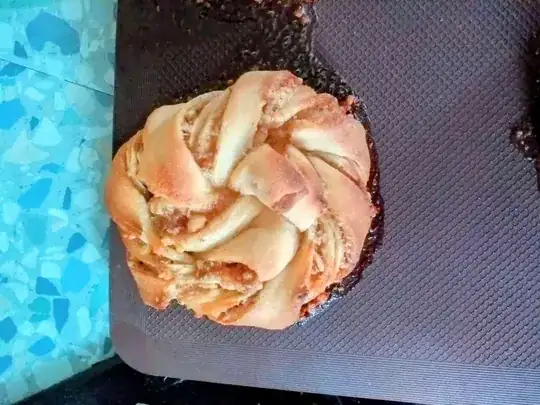 Picture of a knotted pastry with it's filling having leaked during cooking