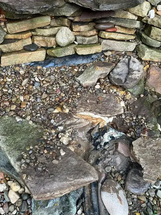 the large rock on the left is shifted down. The hole is below that. 