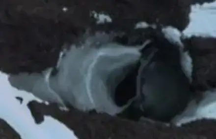 What appears to be a large underground tunnel next to a metal canopy