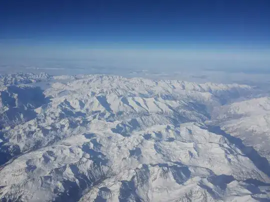 An aerial view of several hundred square miles of snow-covered mountains