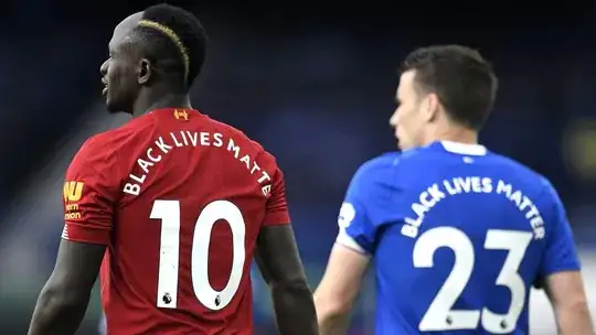 Opposing English football players with "Black Lives Matter" on the back of their jerseys