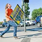 Guy with a square sign for $5.99 Hot-N-Ready Little Caesars Large Pizza